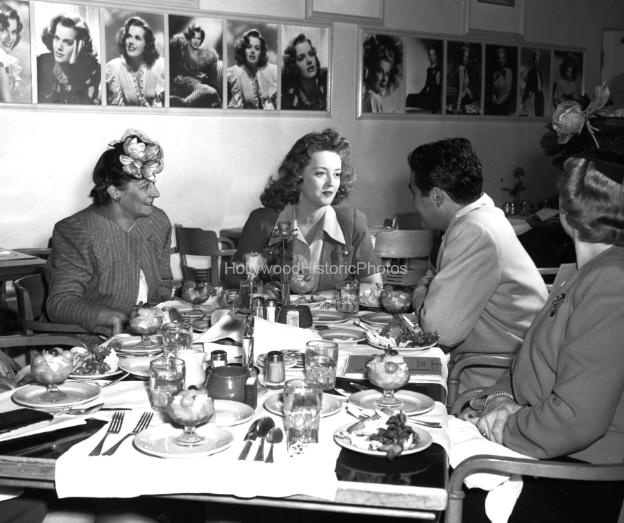 Bette Davis 1940 Having lunch with guests at WB wm.jpg